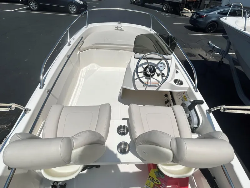 Slide: The Image of 2025 Boston Whaler 130 Super Sport boat interior with dual seats and steering console. - 5