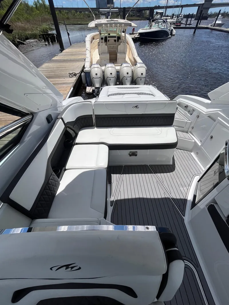 Slide: The Image of 2018 Monterey 328 Super Sport boat interior with luxurious seating at a marina. - 10