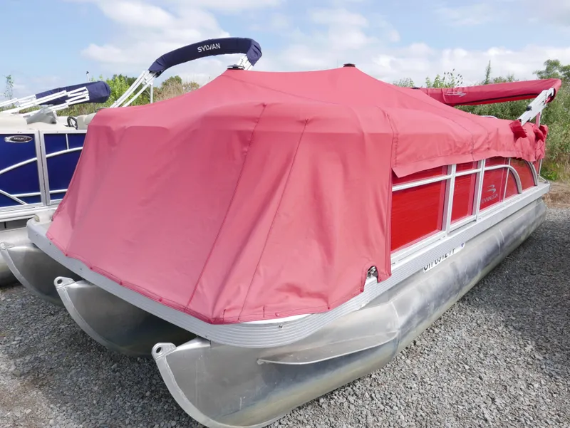 Slide: The Image of 2016 Bennington 208SL pontoon boat with red cover on gravel lot. - 1