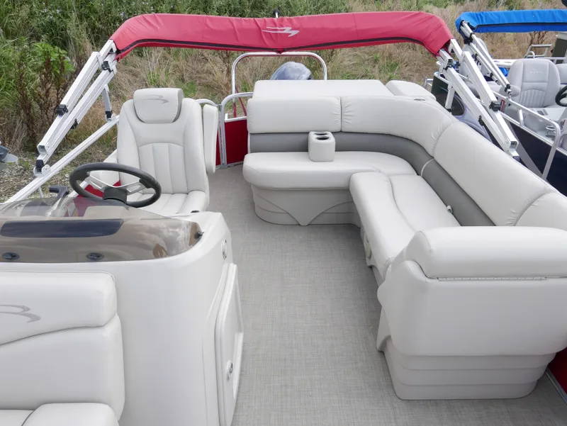 Slide: The Image of 2016 Bennington 208SL pontoon boat interior with white seating and red canopy. - 7