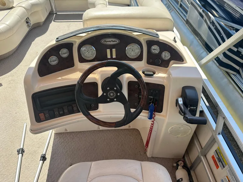 Slide: The Image of 2006 Godfrey Aqua Patio 200 RE boat dashboard with steering wheel and control panel. - 10
