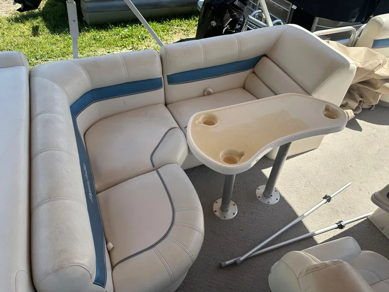 Slide: The Image of 2006 Godfrey Aqua Patio 200 RE boat interior with cushioned seating and table. - 12