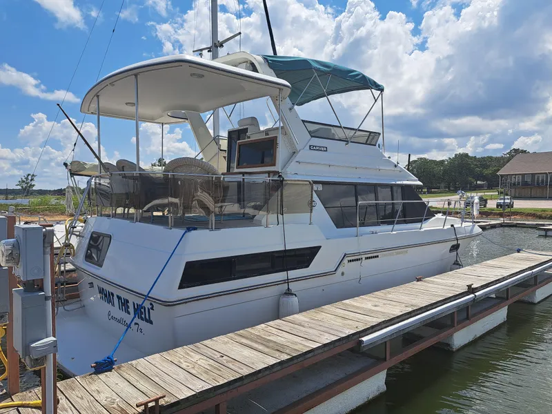 The Image of 1989 Carver 3807 yacht docked at a marina under a partly cloudy sky. - 0