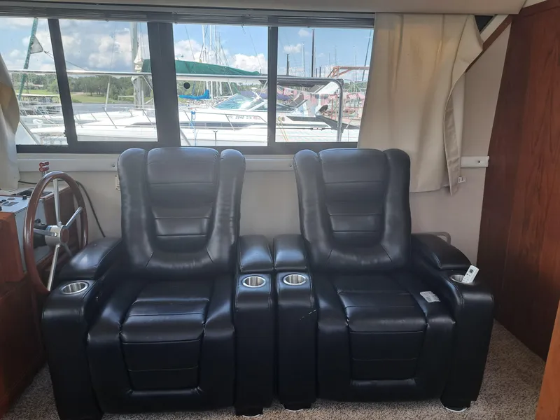 Slide: The Image of Luxurious black leather recliners inside a 1989 Carver 3807 yacht with marina view. - 16