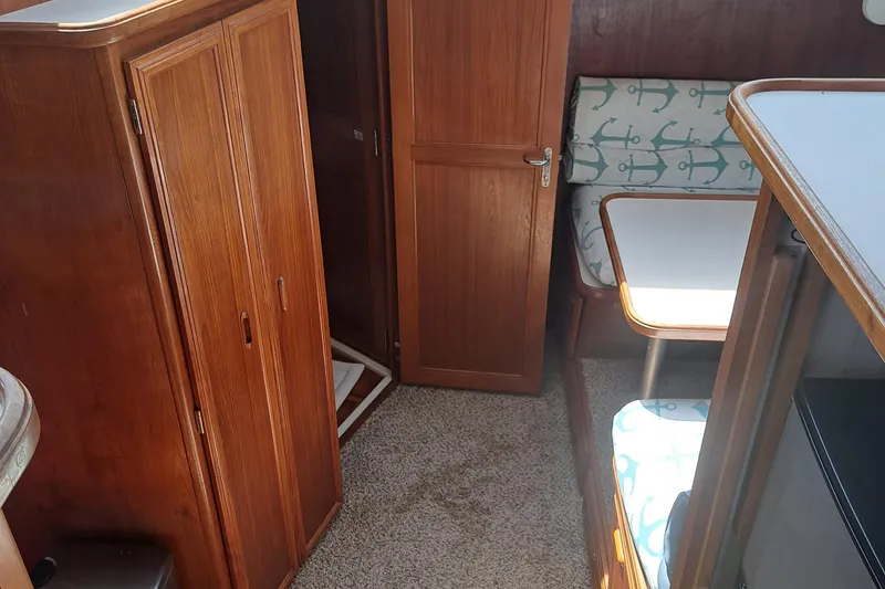 Slide: The Image of Interior of 1989 Carver 3807 yacht with wooden cabinets and anchor-patterned seating. - 18