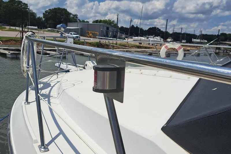 Slide: The Image of 1989 Carver 3807 yacht deck with stainless steel railings at a marina. - 2
