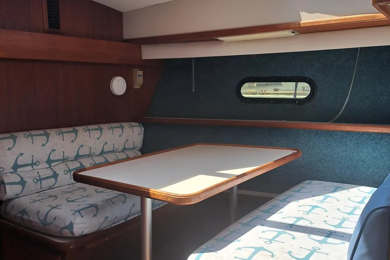 Slide: The Image of 1989 Carver 3807 yacht interior dining area with anchor-patterned seating. - 25
