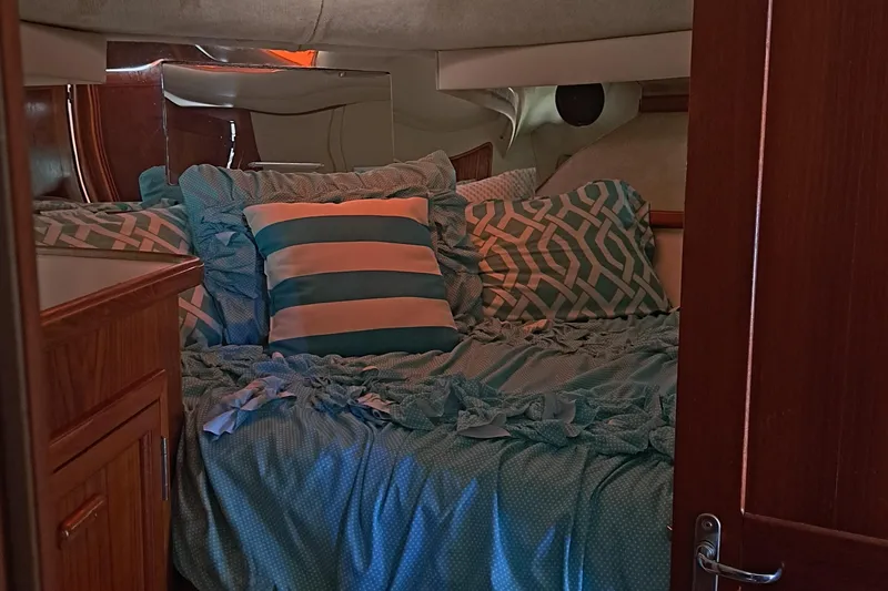Slide: The Image of Cozy bedroom in a 1989 Carver 3807 yacht with blue bedding and striped pillows. - 28