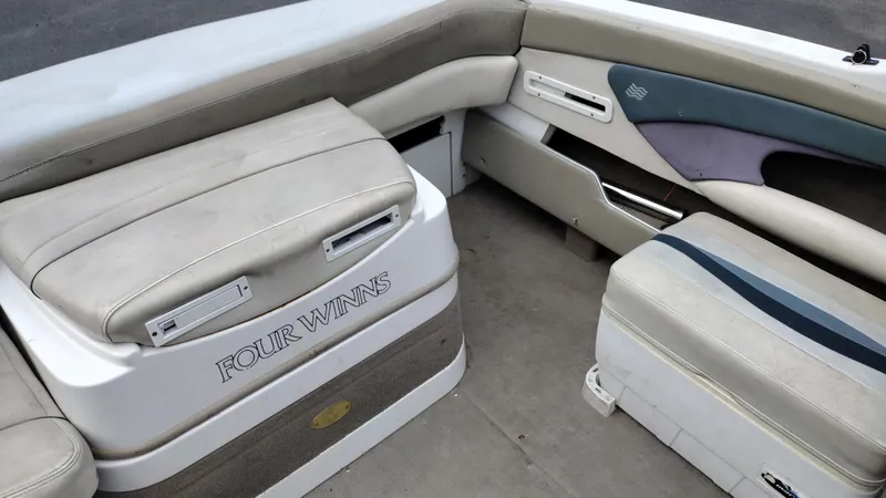 Slide: The Image of 1999 Four Winns 200 Horizon boat interior with cushioned seating and storage compartments. - 18