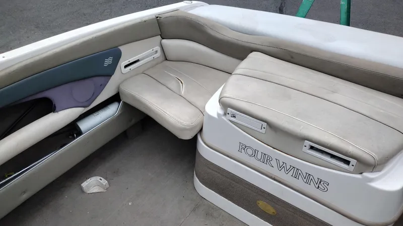 Slide: The Image of 1999 Four Winns 200 Horizon boat interior with beige seating and storage compartments. - 19