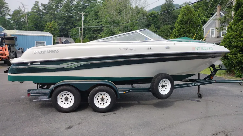 Slide: The Image of 1999 Four Winns 200 Horizon boat on a trailer in a driveway. - 4