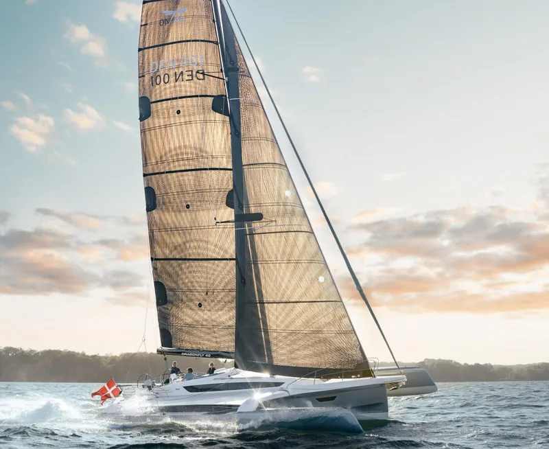 Slide: The Image of Sailing yacht Dragonfly 40, 2026 model, gliding on water at sunset. - 2