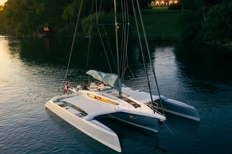 Slide: The Image of 2026 Dragonfly 40 trimaran sailing on calm water at sunset. - 7