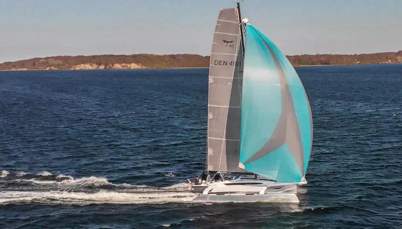Slide: The Image of Sailing yacht Dragonfly 40, 2026 model, gliding on open water with vibrant spinnaker sail. - 8
