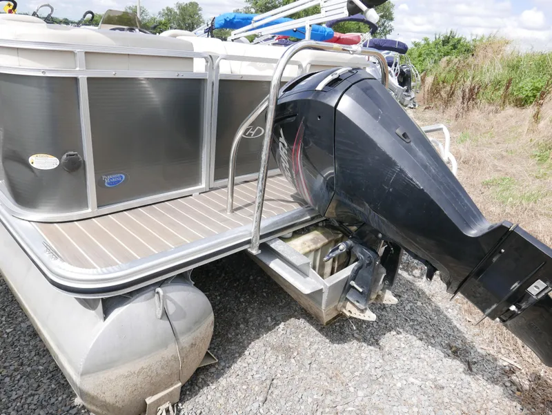 Slide: The Image of 2016 Harris 200 Cruiser pontoon boat with outboard motor on gravel. - 2