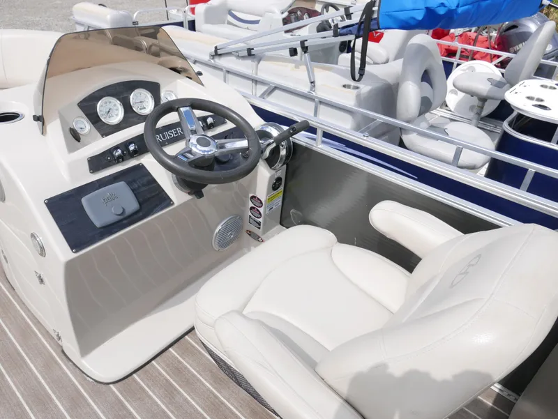 Slide: The Image of 2016 Harris 200 Cruiser boat cockpit with steering wheel and captain's chair. - 8
