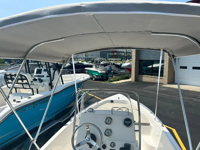 Slide: The Image of 2025 Key West 1720 Center Console boat with canopy at a dealership. - 6