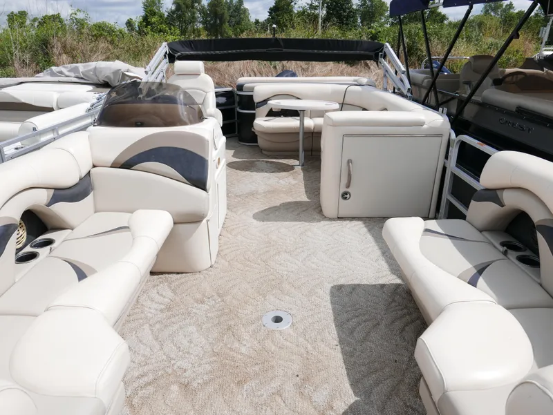 Slide: The Image of 2009 Sylvan Mirage 8520 Cruise pontoon boat interior with beige seating and carpet. - 4