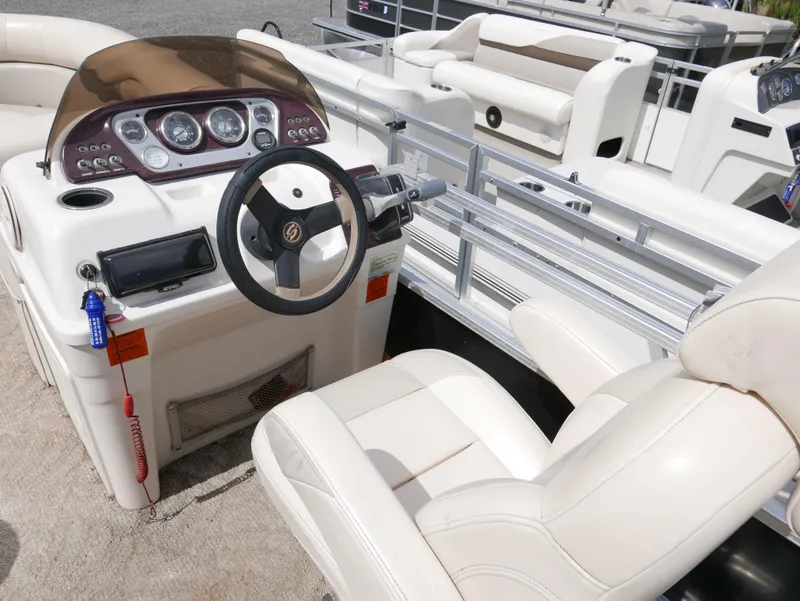 Slide: The Image of 2009 Sylvan Mirage 8520 Cruise boat interior with steering console and seating. - 9