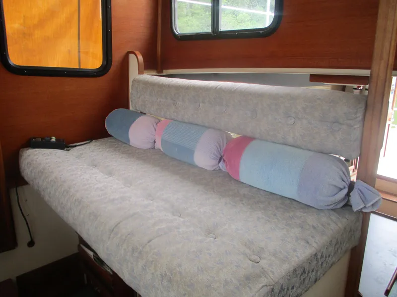 Slide: The Image of Interior seating area of a 1998 Nordic Tug 32 with cushions and windows. - 14