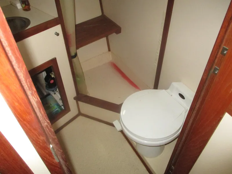 Slide: The Image of Bathroom interior of a 1998 Nordic Tug 32 boat, featuring a compact toilet. - 16
