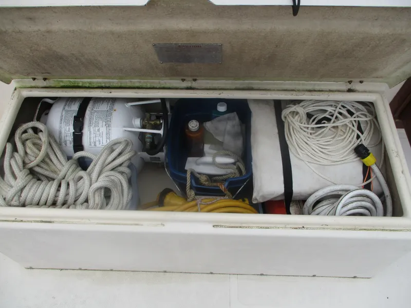 Slide: The Image of Storage compartment on a 1998 Nordic Tug 32 with ropes, propane tank, and supplies. - 22