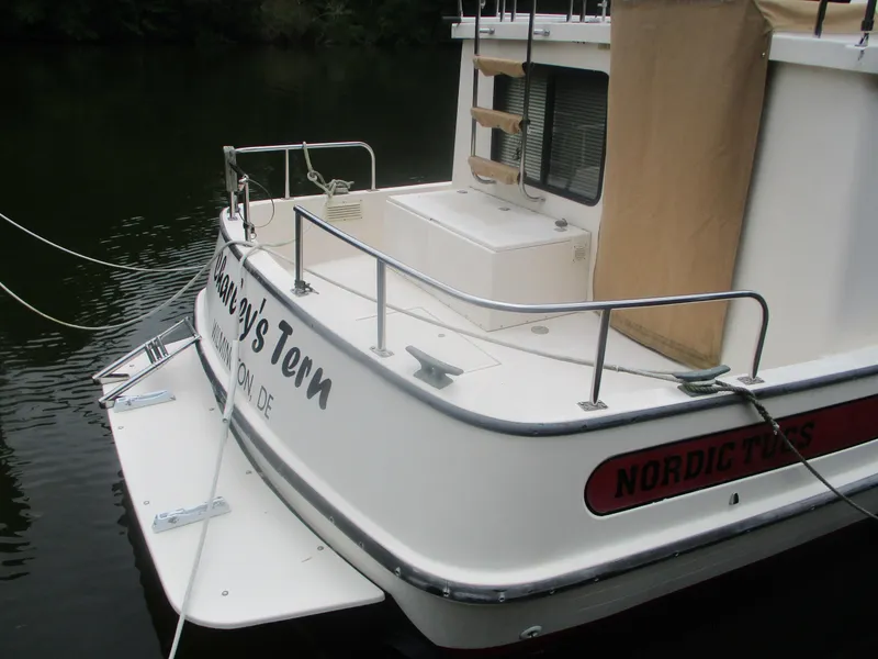 Slide: The Image of 1998 Nordic Tug 32 boat stern view with railing and deck details. - 3