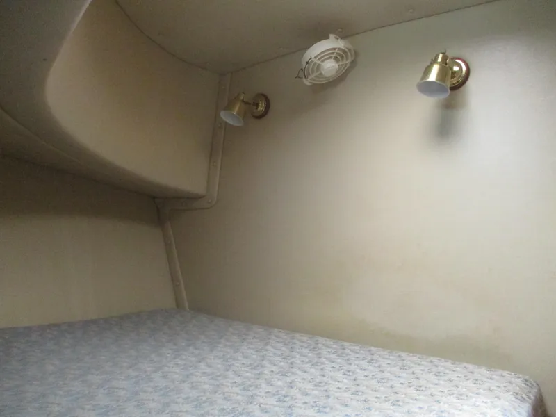 Slide: The Image of 1998 Nordic Tug 32 interior cabin with bed, wall lights, and fan. - 30