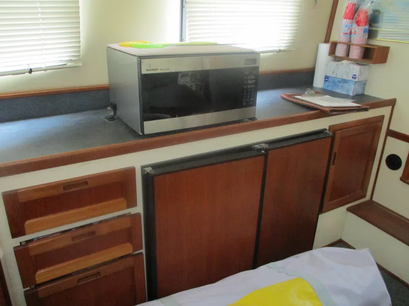 Slide: The Image of 1998 Nordic Tug 32 interior with microwave, wooden cabinets, and countertop. - 7