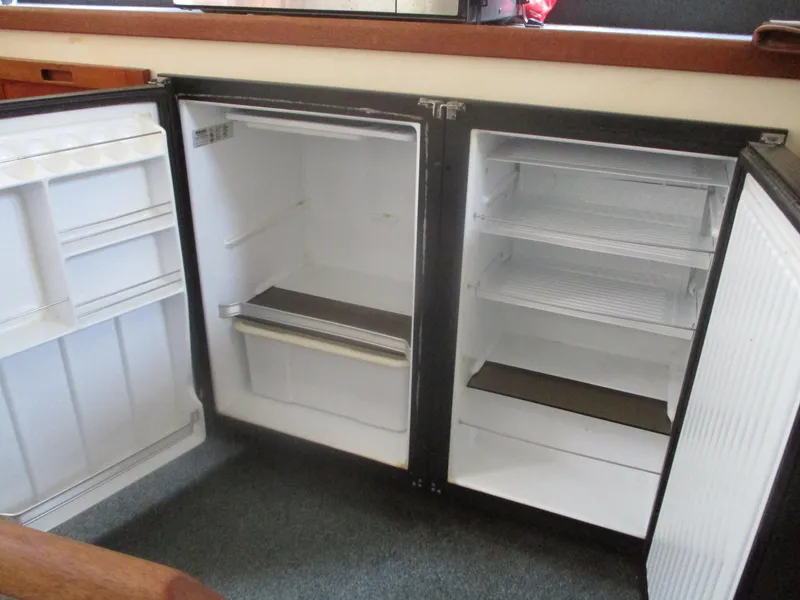 Slide: The Image of Open refrigerator in 1998 Nordic Tug 32 boat interior, showing empty shelves and compartments. - 8