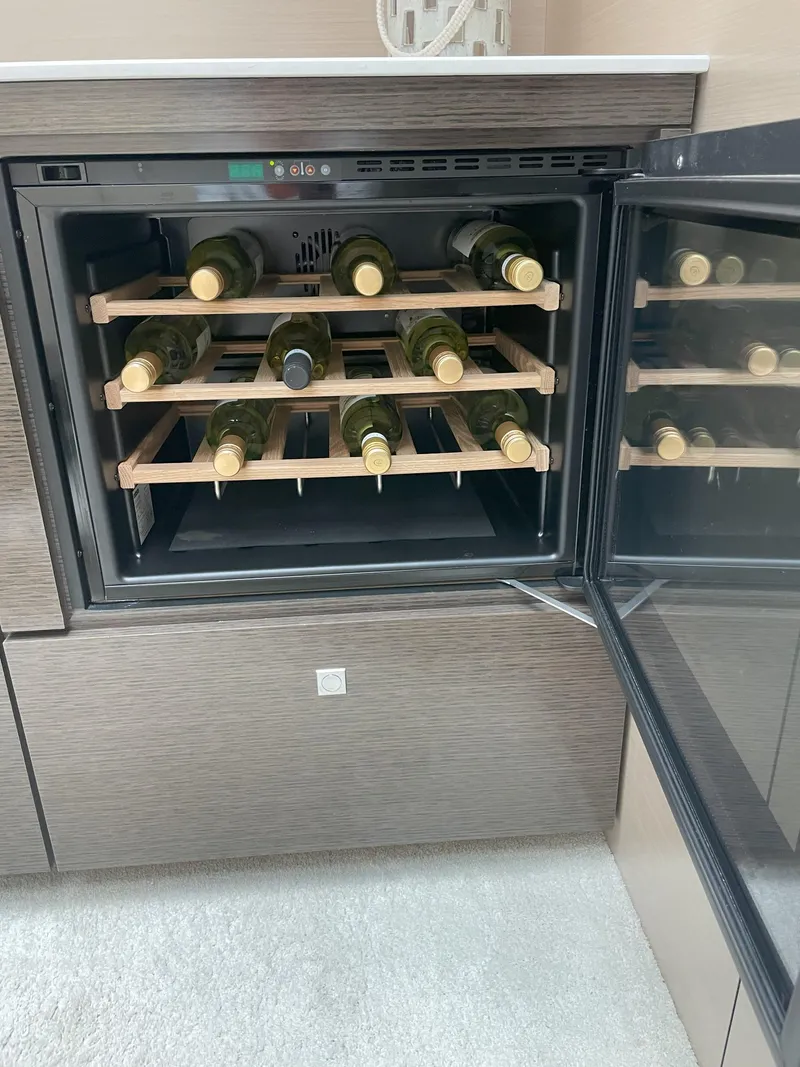 Slide: The Image of Wine cooler with bottles inside a 2021 Cruisers Yachts 54 Cantius. - 13