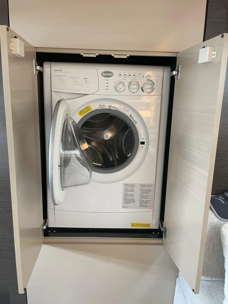 Slide: The Image of Washing machine in 2021 Cruisers Yachts 54 Cantius, behind open cabinet doors. - 14