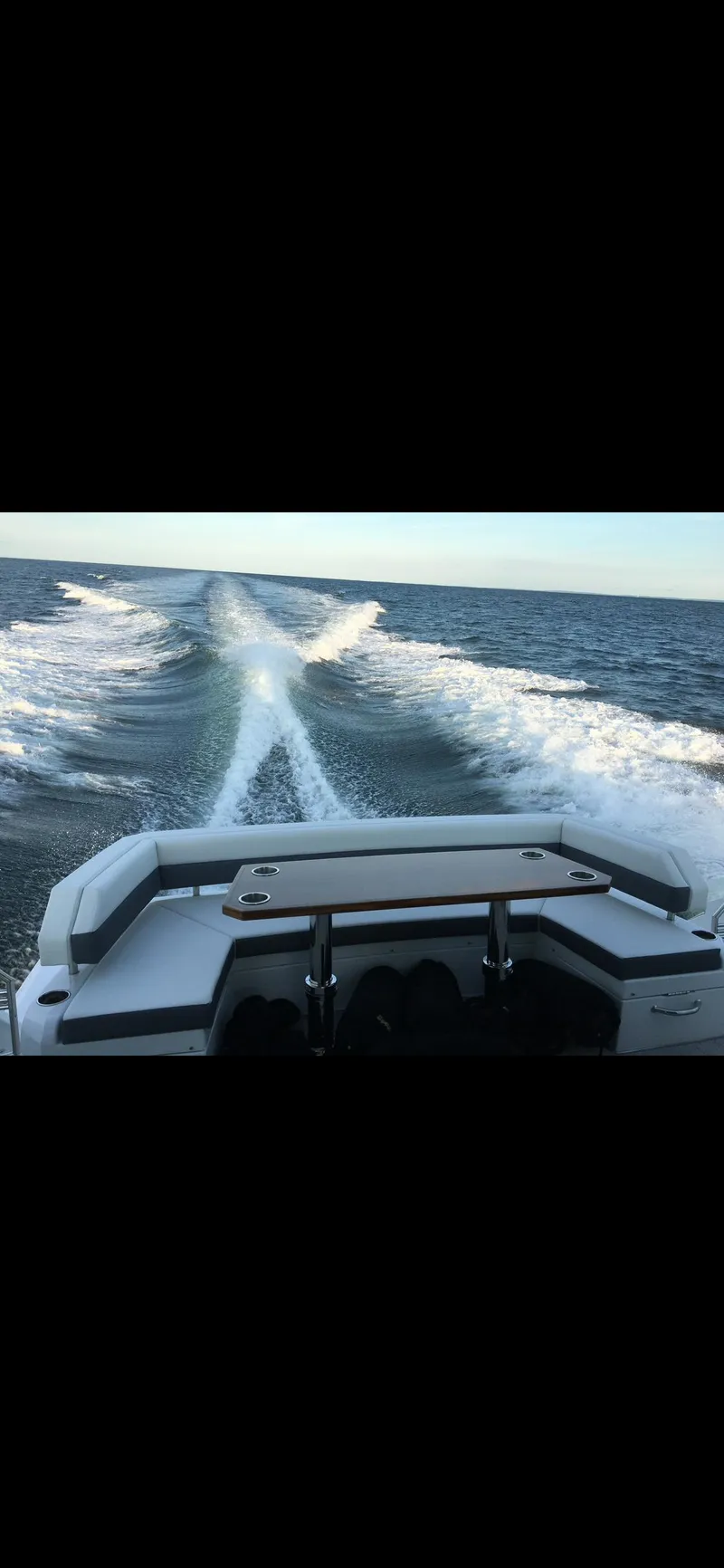 Slide: The Image of 2021 Cruisers Yachts 54 Cantius cruising on open water, leaving a wake trail. - 32