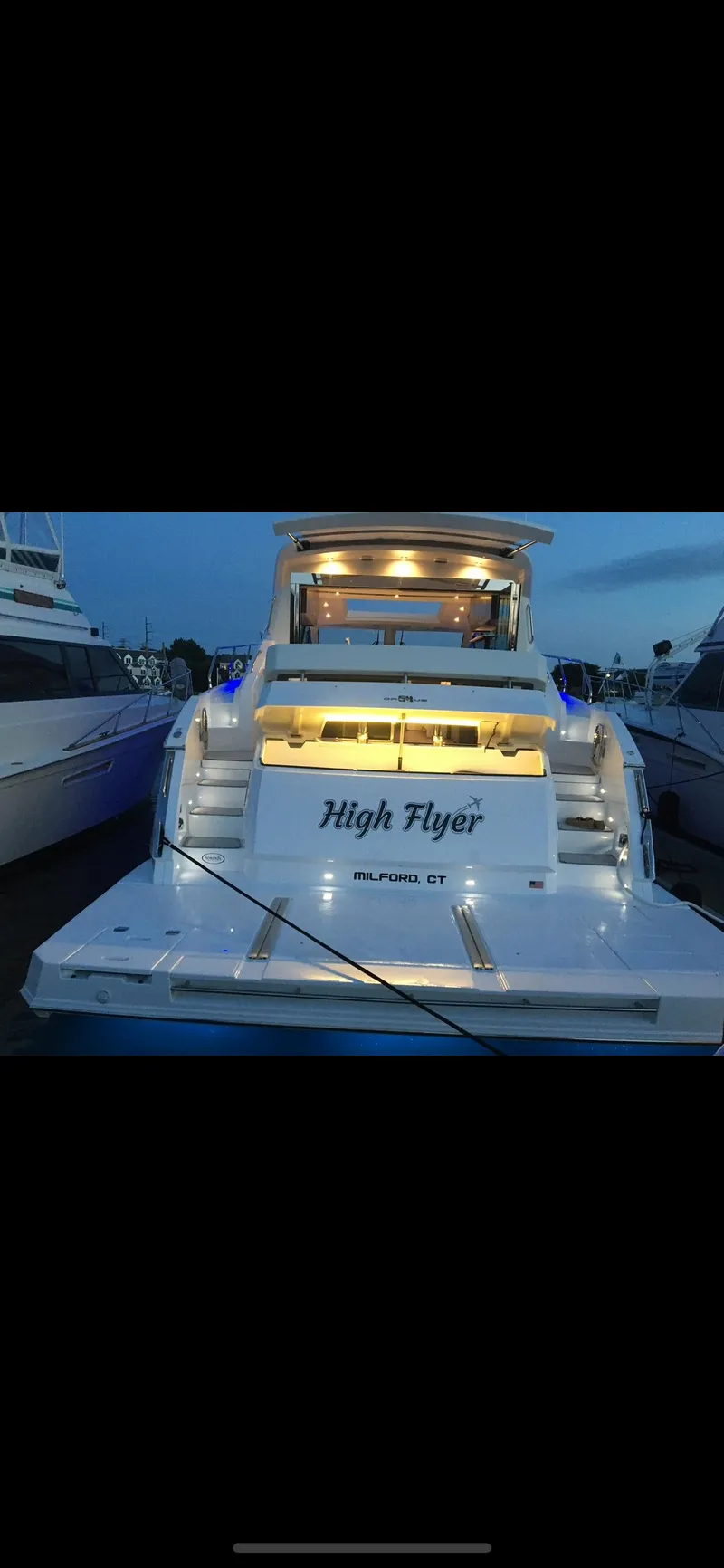 Slide: The Image of 2021 Cruisers Yachts 54 Cantius docked at sunset, rear view with illuminated deck. - 34