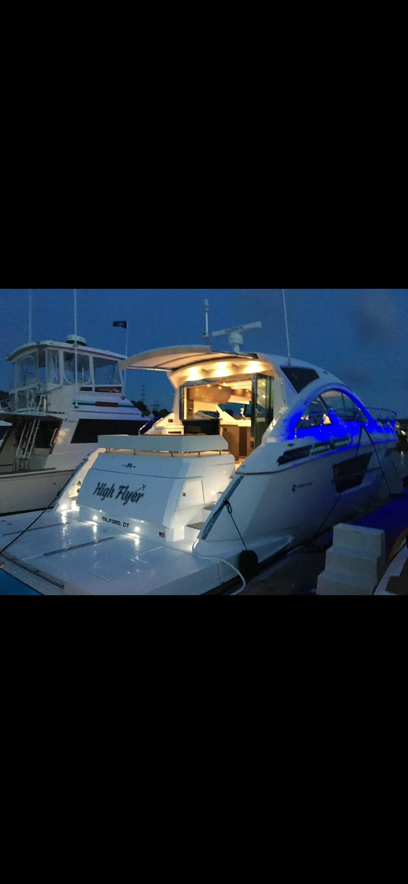Slide: The Image of 2021 Cruisers Yachts 54 Cantius with illuminated deck at night, docked in marina. - 35