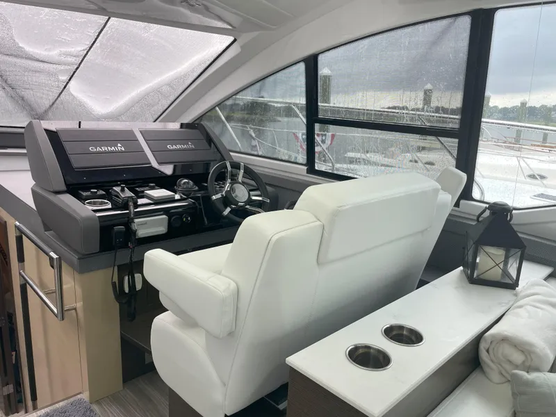 Slide: The Image of 2021 Cruisers Yachts 54 Cantius helm with modern controls and white seating. - 39