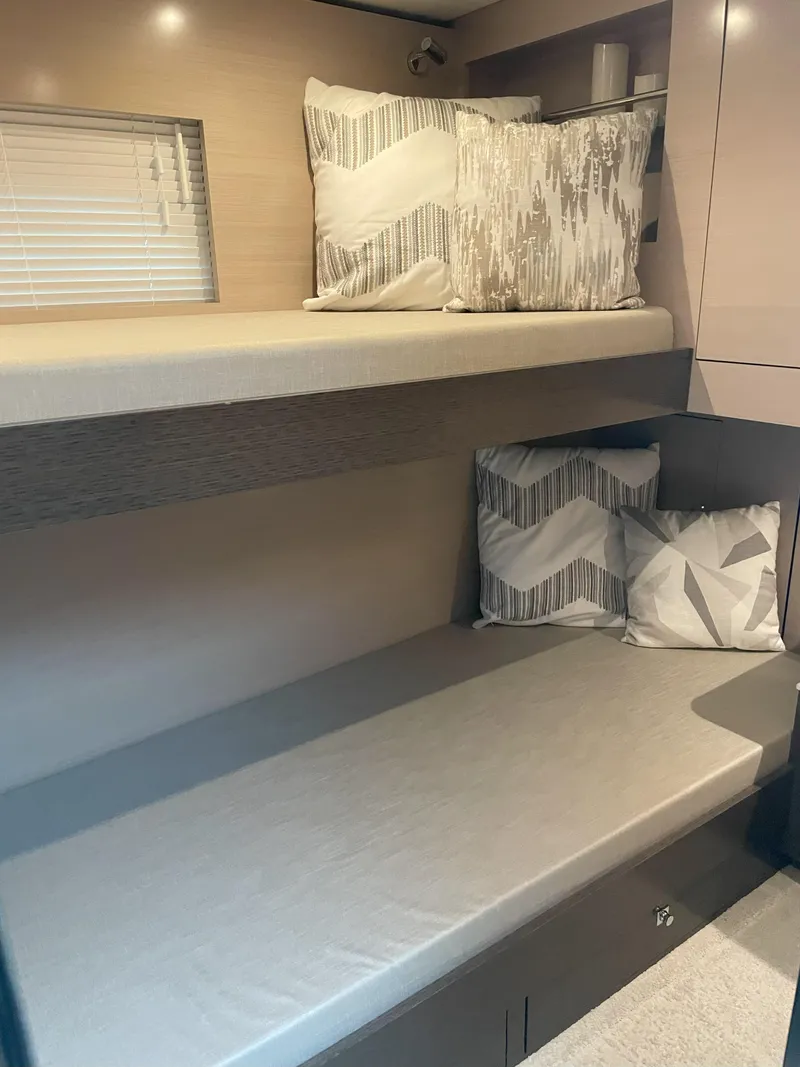 Slide: The Image of 2021 Cruisers Yachts 54 Cantius interior with bunk beds and decorative pillows. - 4