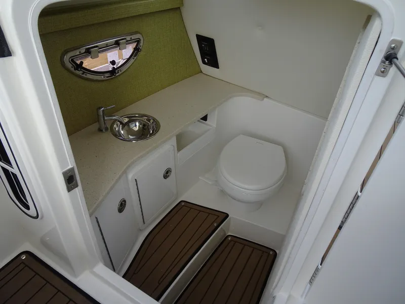 Slide: The Image of 2018 Cobalt R30 boat bathroom with sink, toilet, and wooden floor mats. - 24