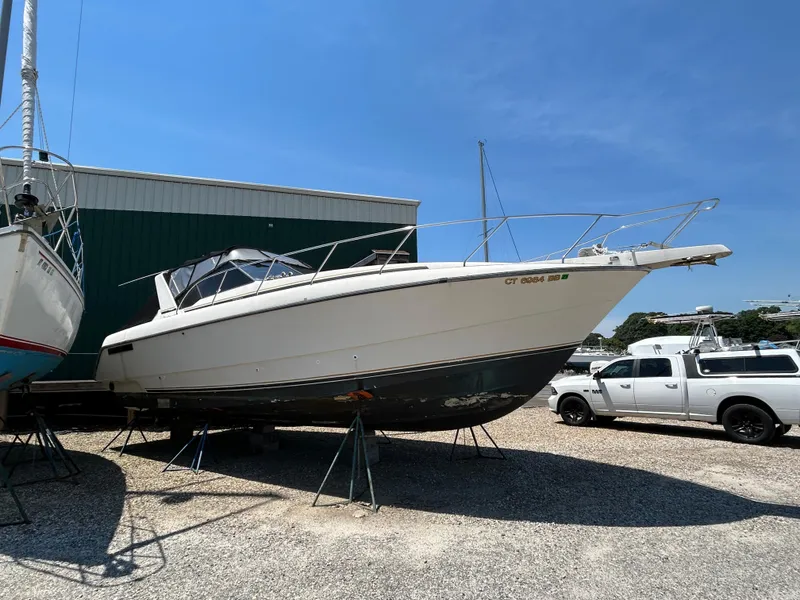 The Image of 1991 Silverton 34 Express Cruiser boat on stands in a boatyard. - 0