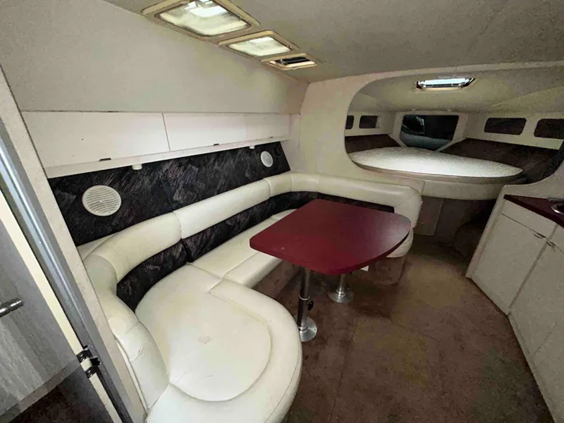 Slide: The Image of 1991 Silverton 34 Express Cruiser interior with white seating and red table. - 12