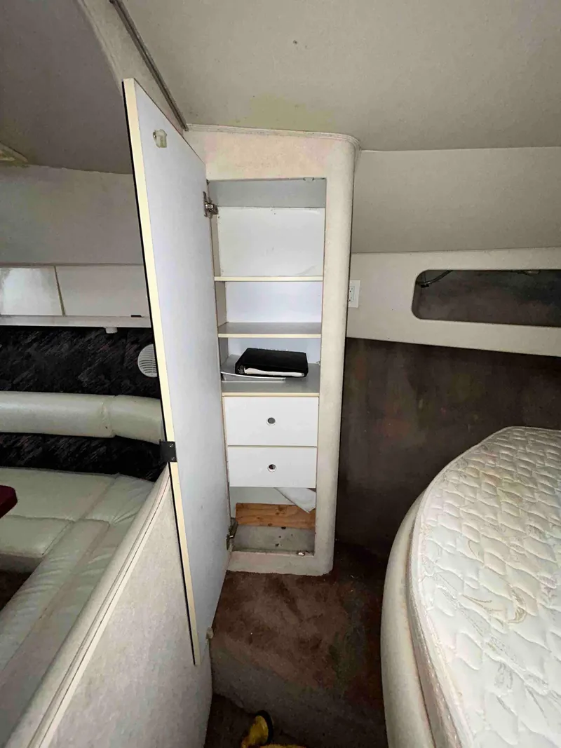 Slide: The Image of Interior of 1991 Silverton 34 Express Cruiser with open storage cabinet and bed. - 16