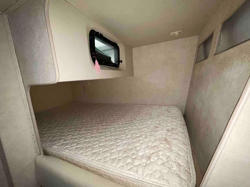 Slide: The Image of 1991 Silverton 34 Express Cruiser cabin with a cozy bed and small window. - 24