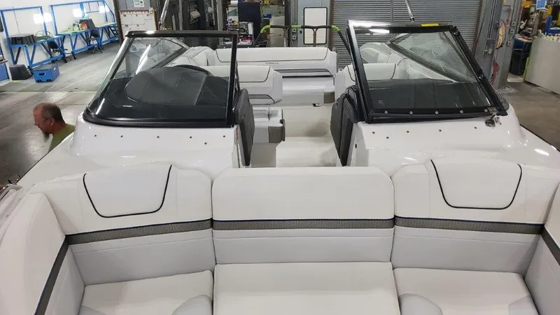 Slide: The Image of 2025 Formula 240 Bowrider interior with white seating and dual windshields in a workshop. - 15