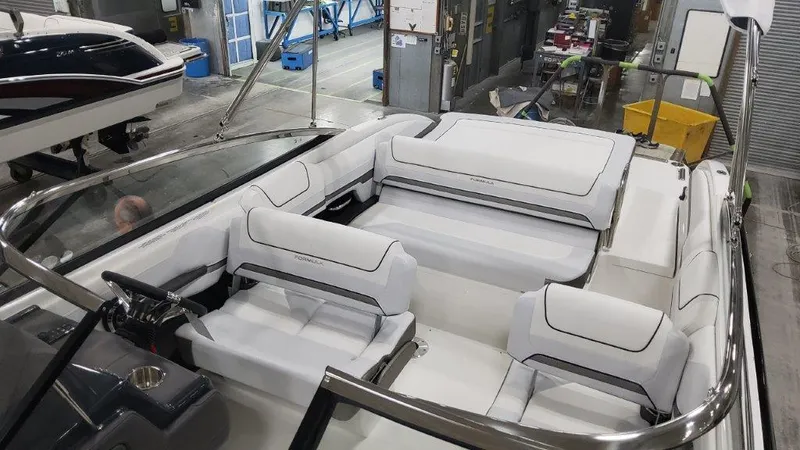 Slide: The Image of 2025 Formula 240 Bowrider interior with white seating in a boat manufacturing facility. - 16