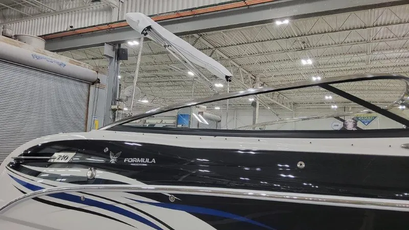 Slide: The Image of 2025 Formula 240 Bowrider boat in a showroom, side view. - 2