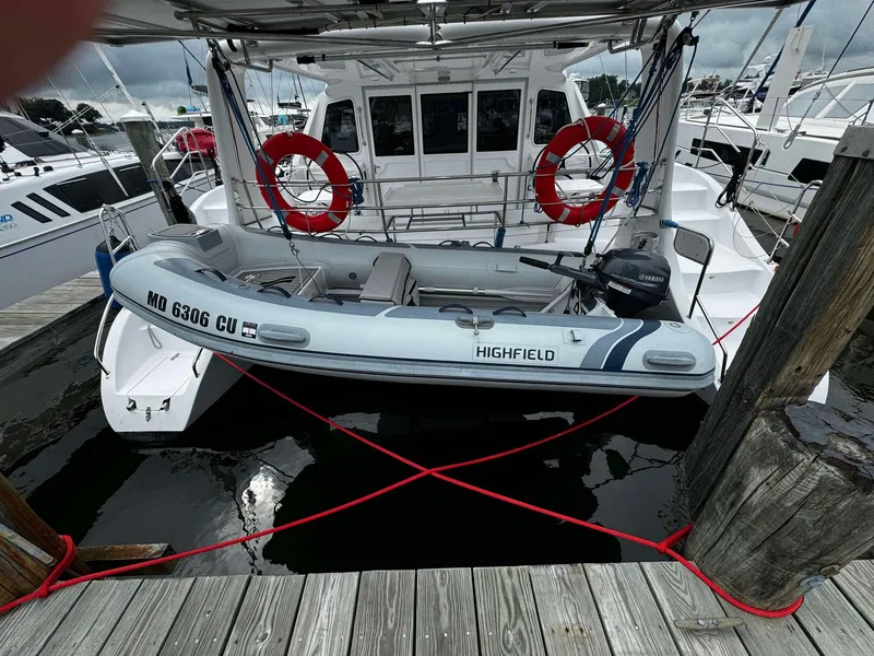 Slide: The Image of Seawind 1160 Lite 2023 catamaran with a Highfield dinghy docked at a marina. - 8