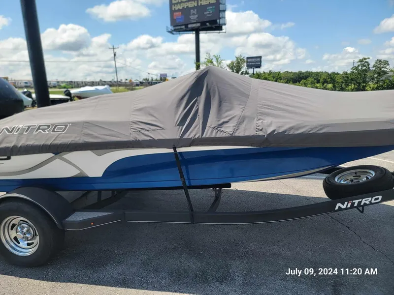 Slide: The Image of 2018 Nitro Z19 Sport boat covered on trailer, outdoor setting, sunny day. - 9