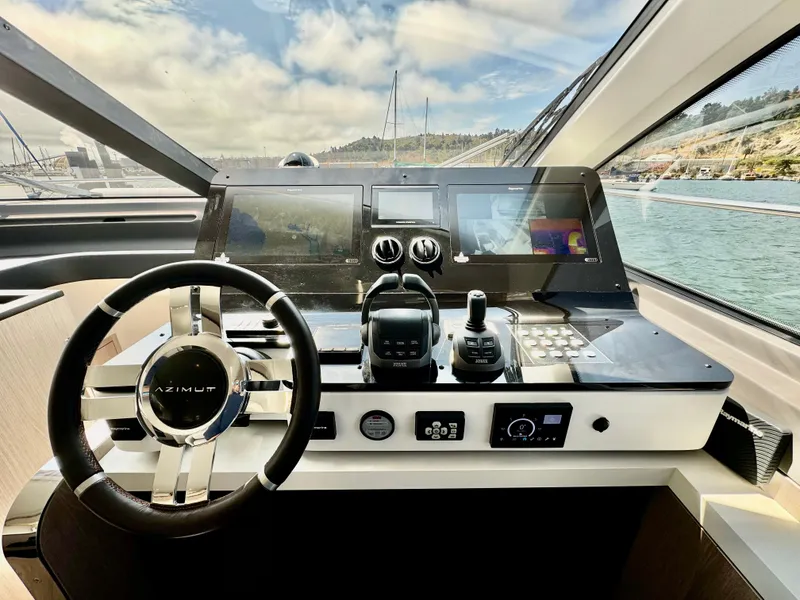 Slide: The Image of 2024 Azimut Fly 60 yacht helm with modern navigation controls and panoramic view. - 13