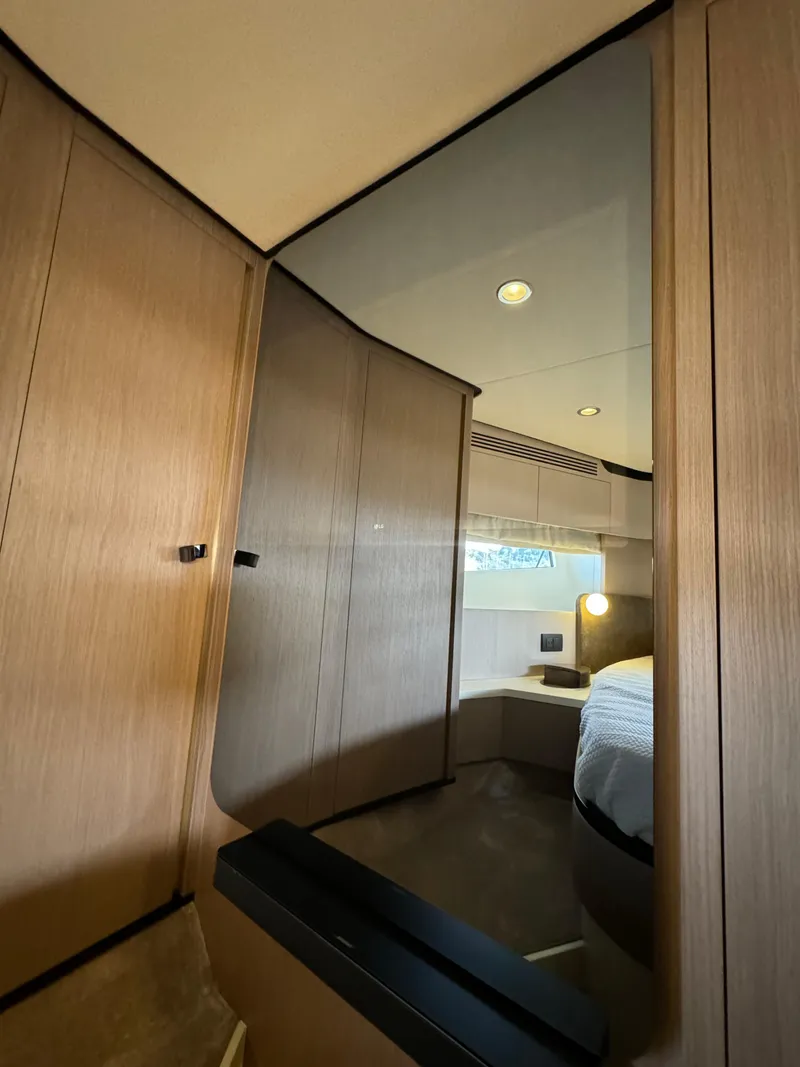 Slide: The Image of 2024 Azimut Fly 60 yacht interior with modern wood paneling and cozy bedroom. - 20