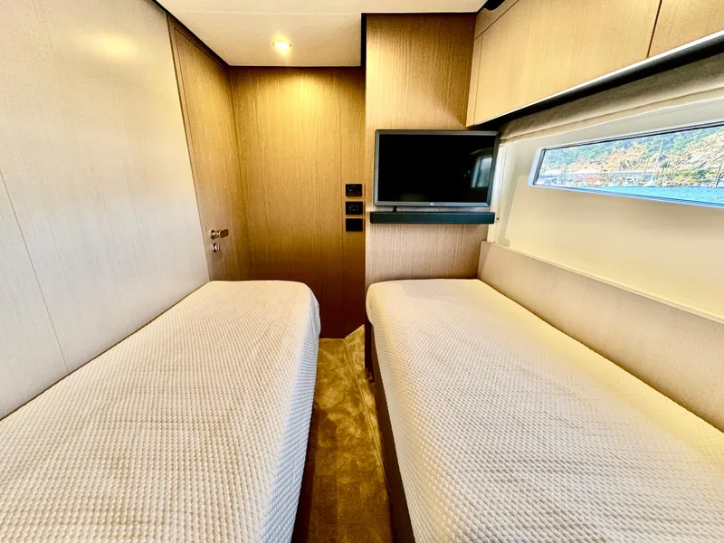 Slide: The Image of 2024 Azimut Fly 60 yacht cabin with twin beds and a wall-mounted TV. - 33